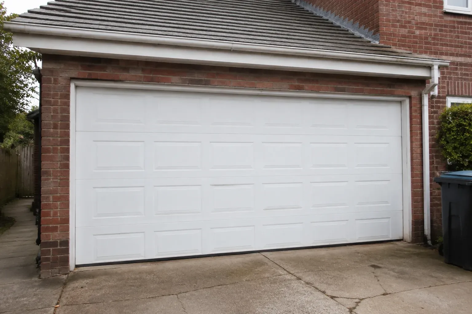 Closed white sectional garage door at an ordinary brick house. — Sectional Garage Door Replacement, Oakville